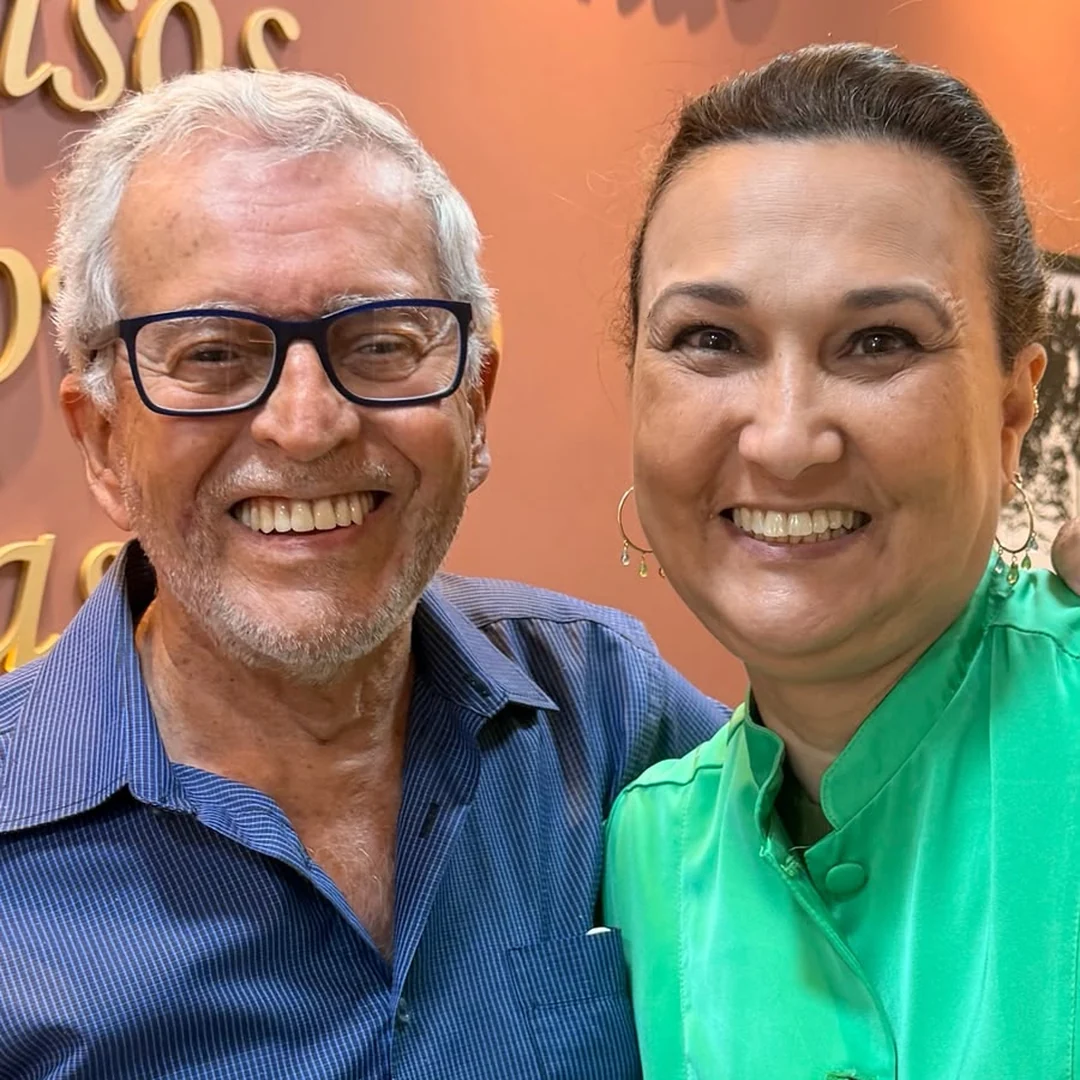 Paciente sorrindo ao lado da Dra. Cristiane Almeida durante registro fotográfico no consultório.